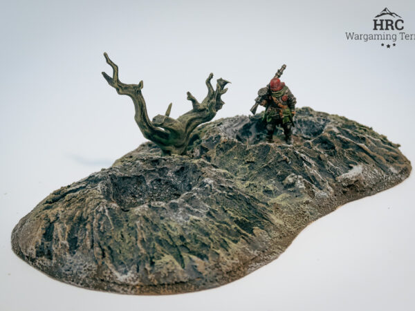 lose-up of cracked earth and stone fragments on a handcrafted wargaming crater.